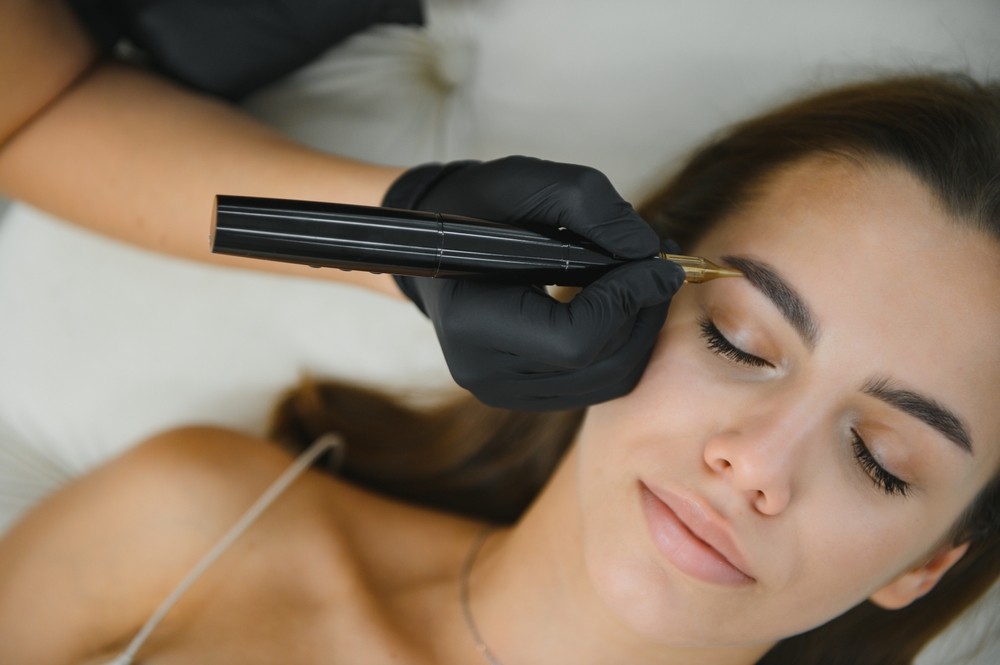 Woman receiving eyebrow microblading, a semi-permanent treatment that typically fades gradually over 1 to 3 years.